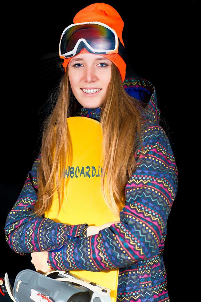 garota loira com cabelo comprido com snowboard e roupas esportivas de inverno em estúdio foto