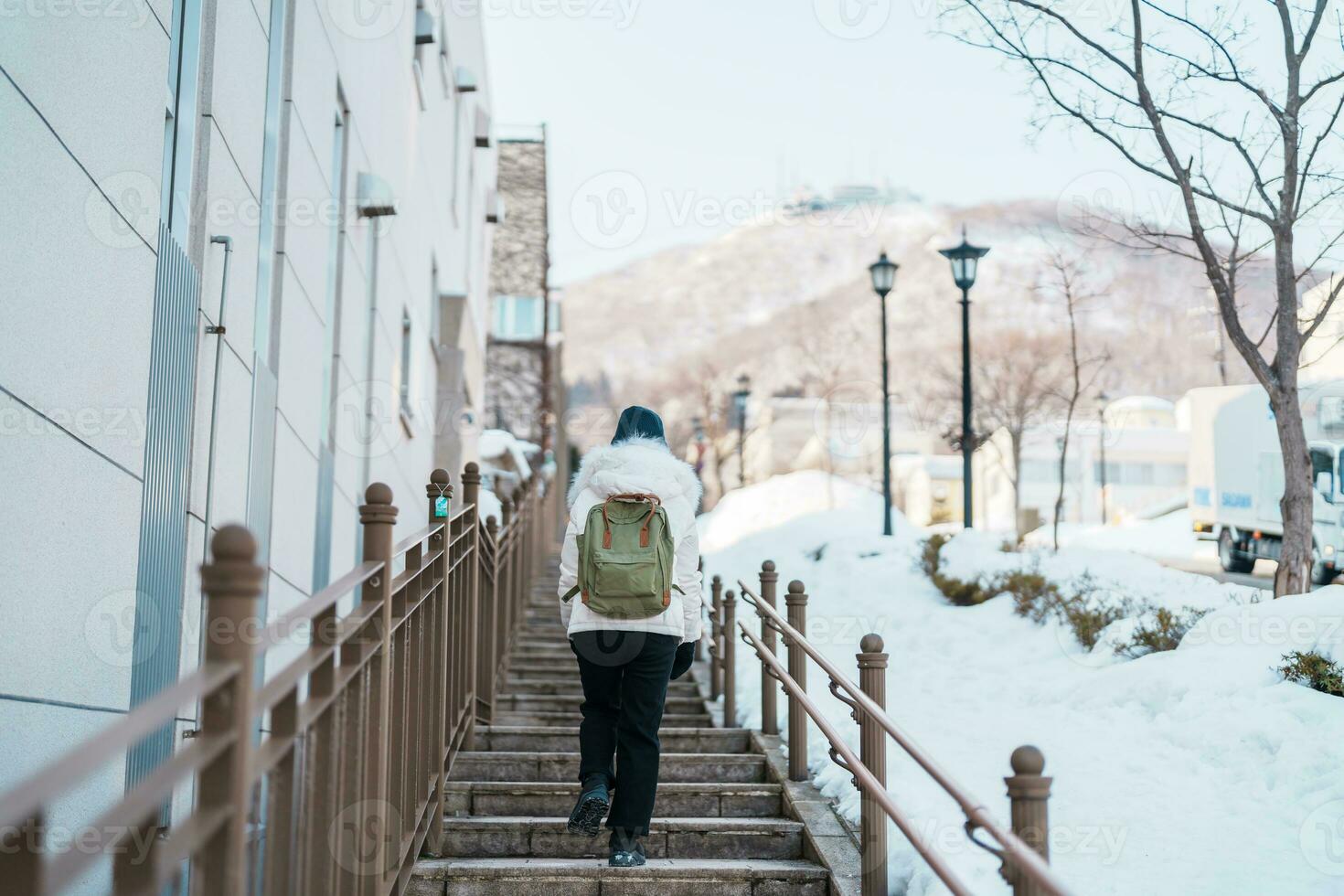 mulher turista visitando dentro hakodate, viajante dentro suéter passeios turísticos hachiman zaka declive com neve dentro inverno. ponto de referência e popular para atrações dentro Hokkaido, Japão. viagem e período de férias conceito foto