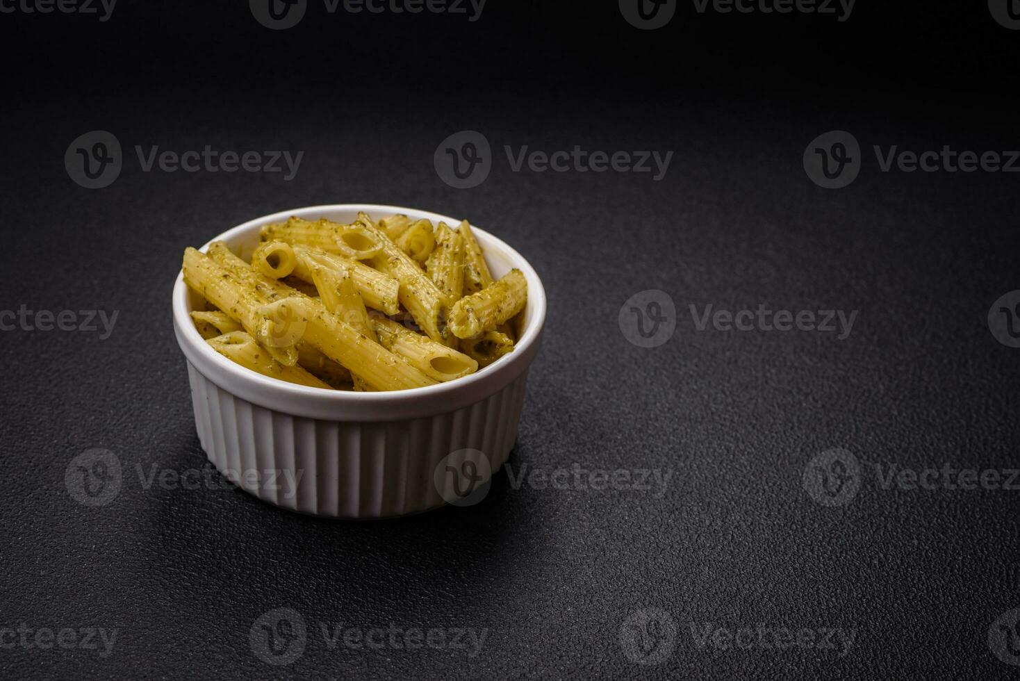 delicioso fresco massa Macarrão Penne com verde pesto molho com manjericão, sal e especiarias foto