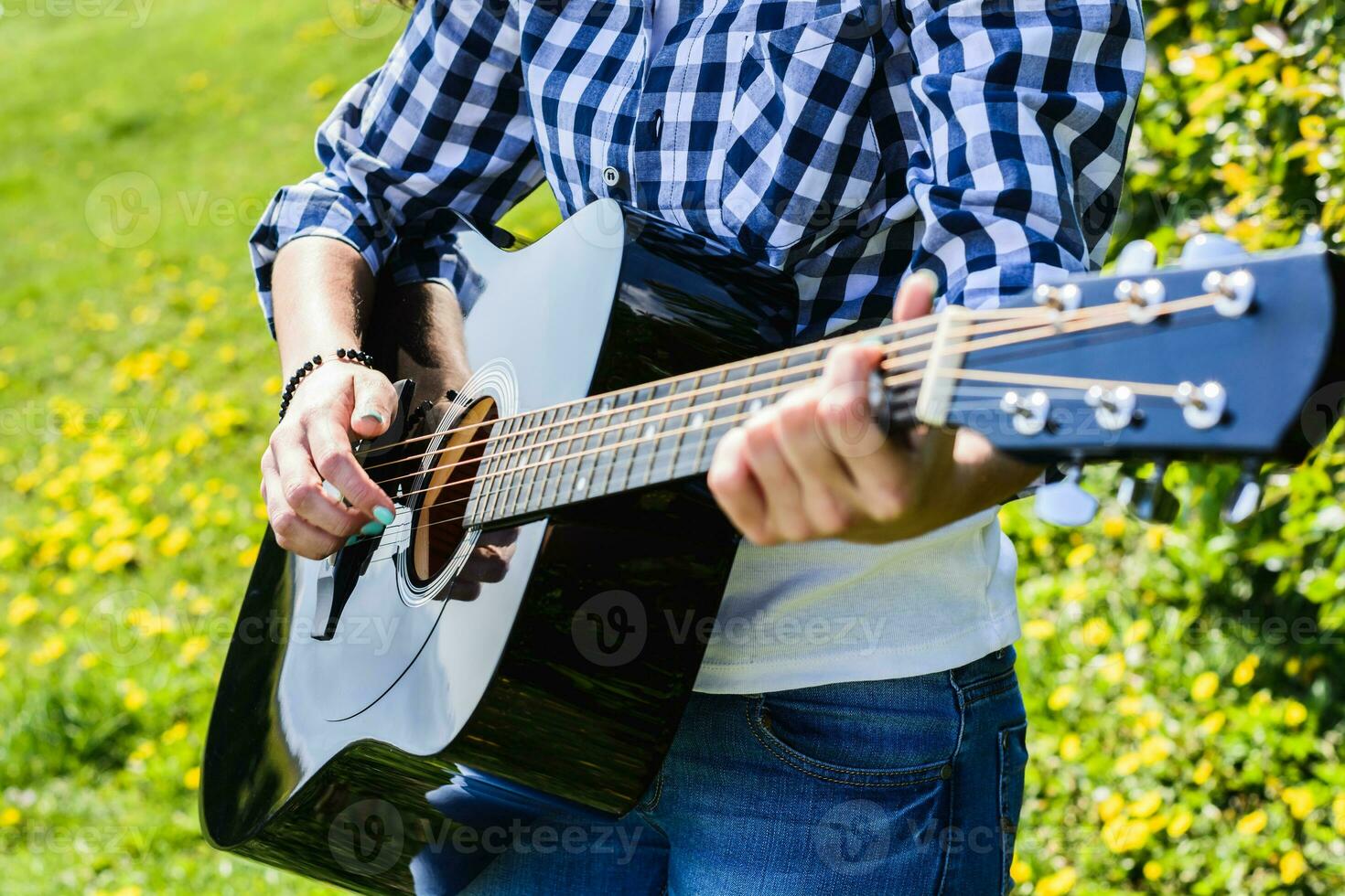 menina em uma verde Prado jogando guitarra foto