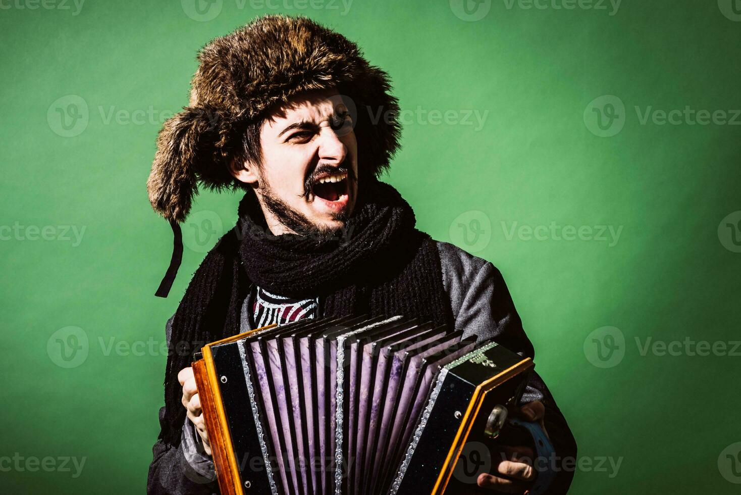 uma muito positivo homem com a acordeão posando dentro a estúdio foto