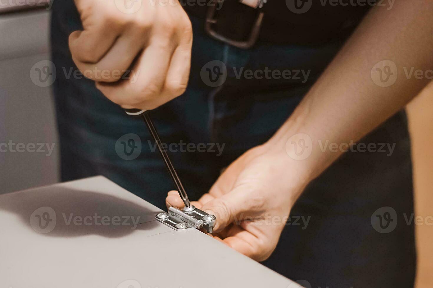 mobília montador instala dobradiças. mecânico trabalho com Chave de fenda. mãos aguarde reparar ferramenta. pequeno o negócio apoiar. estilo de vida trabalhar. foto