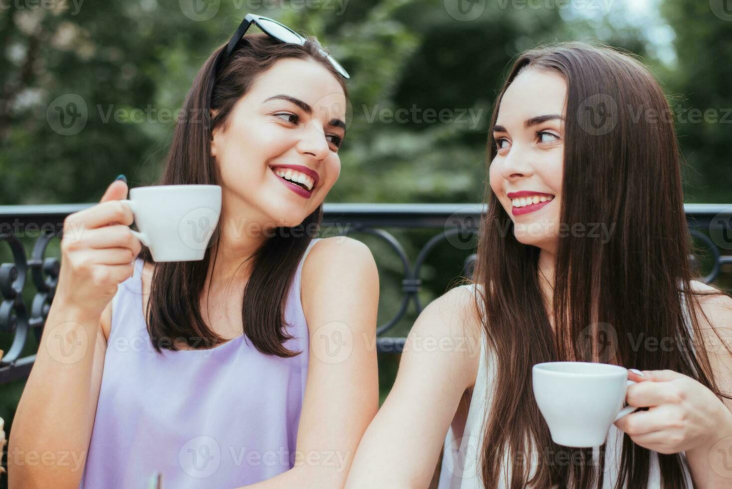 amigas estão sentado dentro café e bebendo chá foto