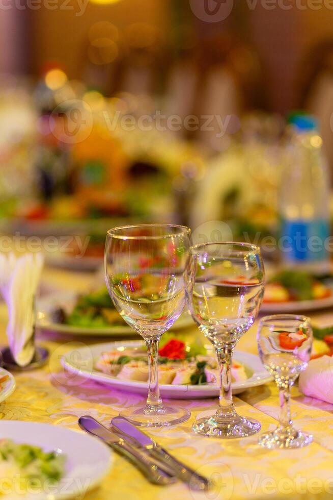 servido festivo mesa com lanches, copos, copos, talheres e guardanapos para uma banquete foto