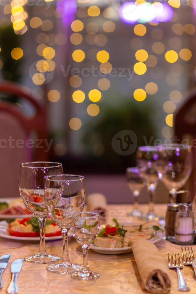 servido festivo mesa com lanches, copos, copos, talheres e guardanapos para uma banquete foto