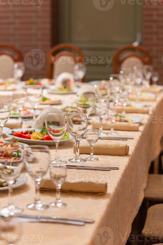 servido festivo mesa com lanches, copos, copos, talheres e guardanapos para uma banquete foto