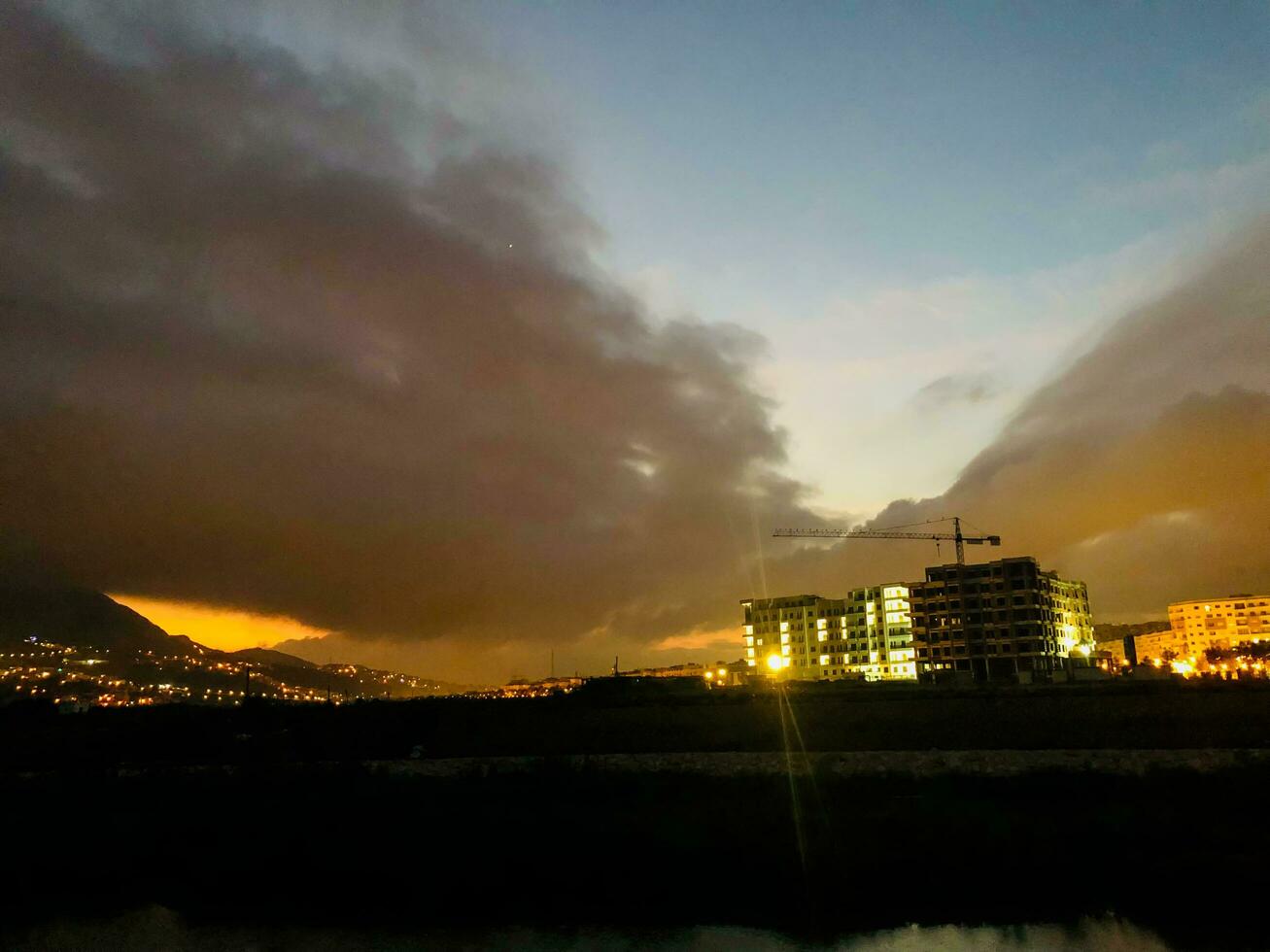 uma Visão do a cidade às crepúsculo com nuvens e edifícios foto