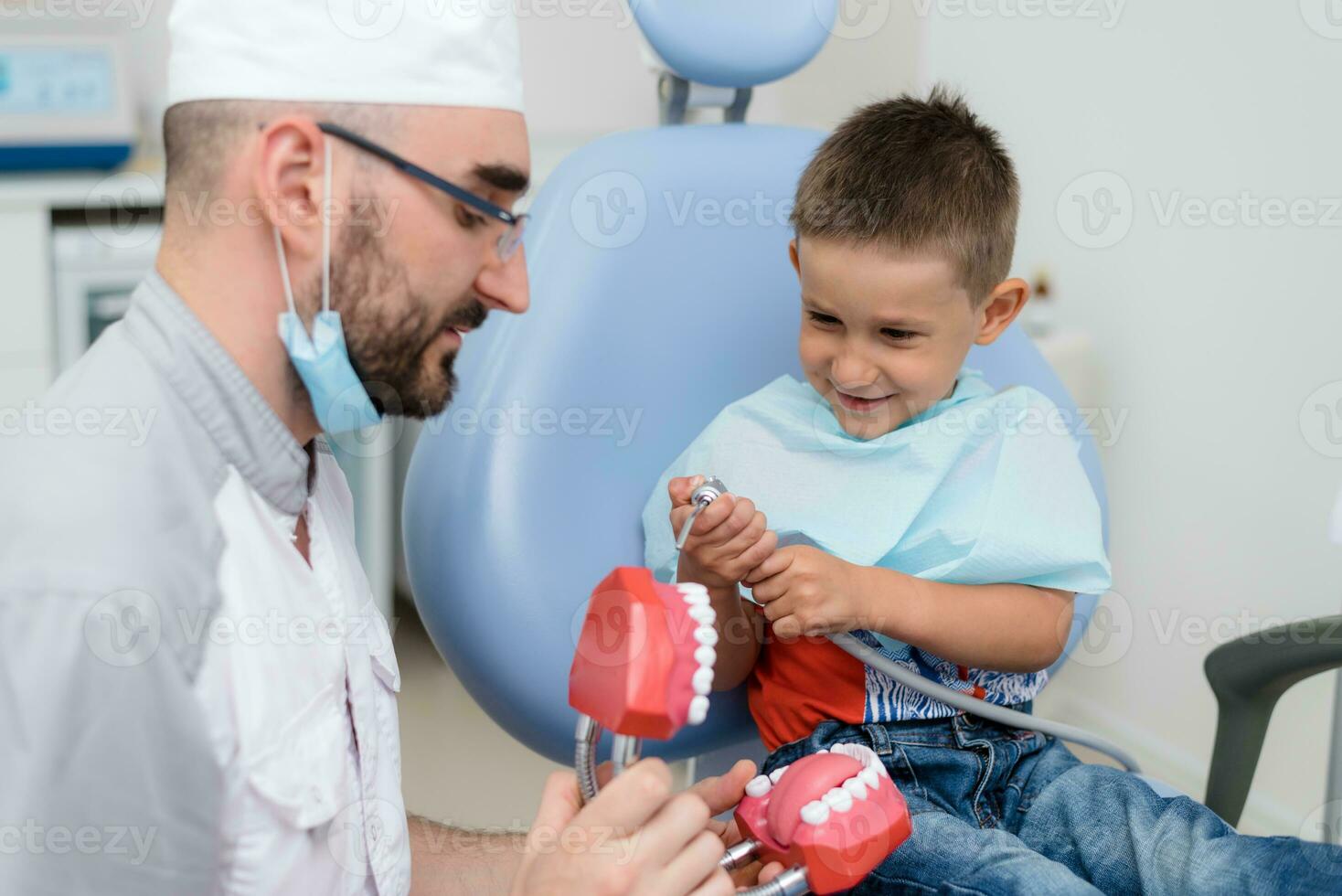a dentista tocam com uma pequeno paciente tão este ele é não receoso para tratar dele dentes foto