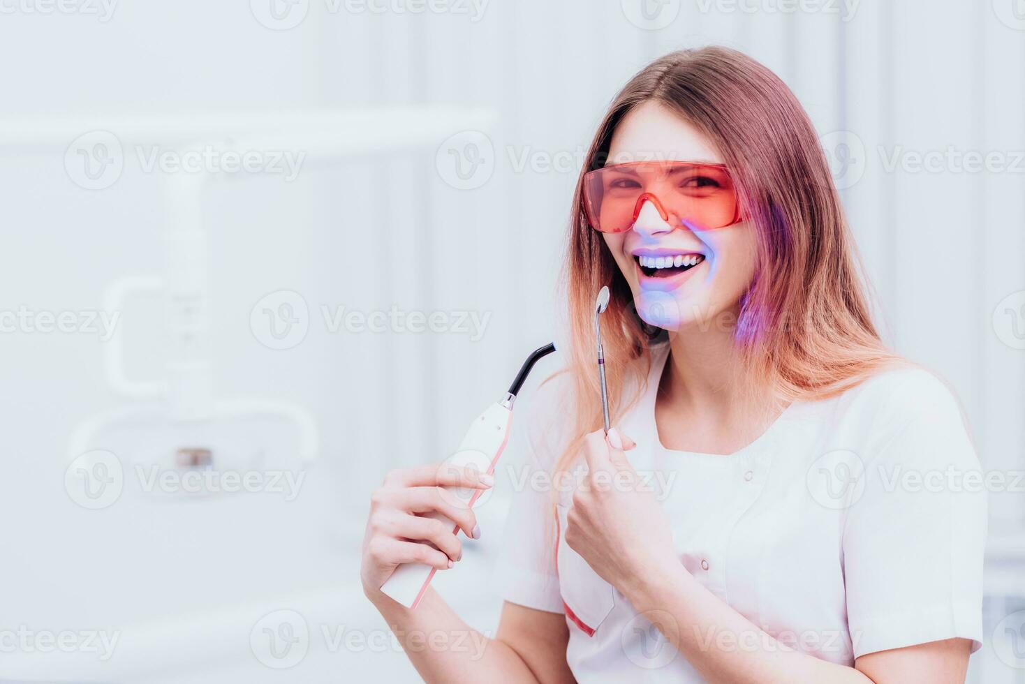 lindo menina ortodontista posando com instrumentos dentro clínica foto