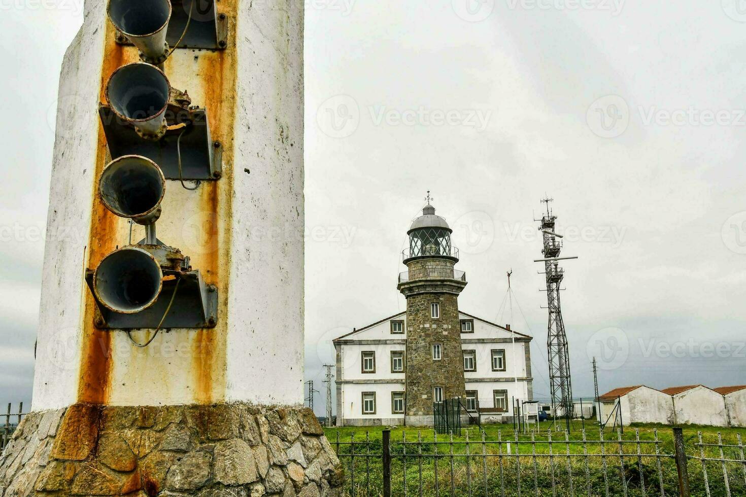 uma farol com uma ampla torre dentro a primeiro plano foto