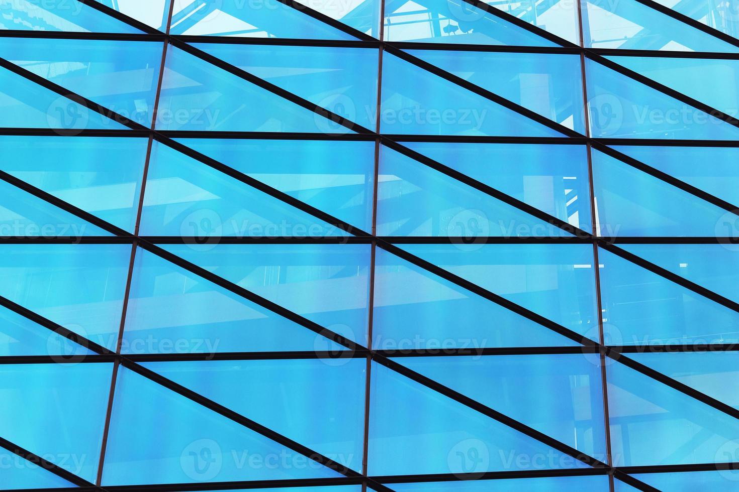 parede da janela de vidro de um edifício moderno com reflexo do céu azul foto