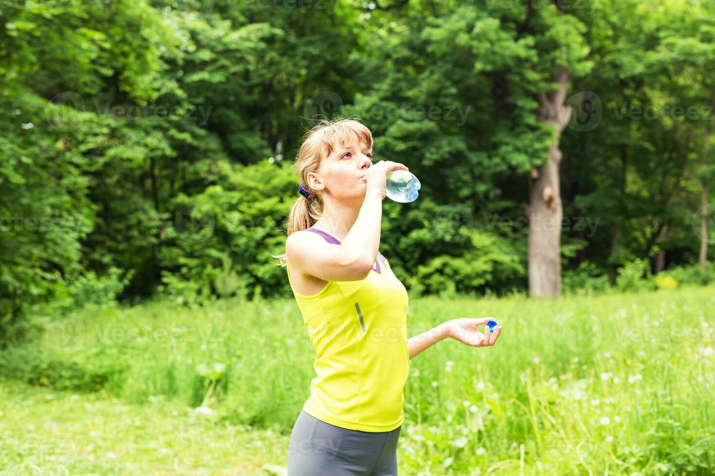 mulher de aptidão bebendo água de garrafa. foto