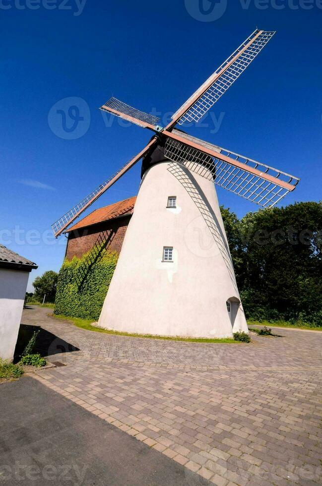 uma moinho de vento é mostrando dentro uma rural área foto