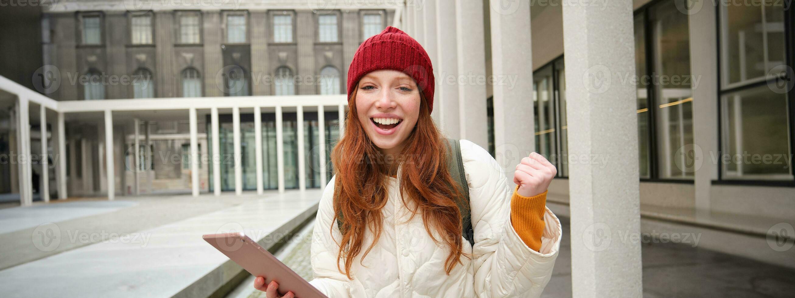 à moda gengibre garota, turista anda em com digital tábua por aí cidade, mulher conecta para internet em dela engenhoca, olhando acima Informação, mensagens de texto mensagem foto