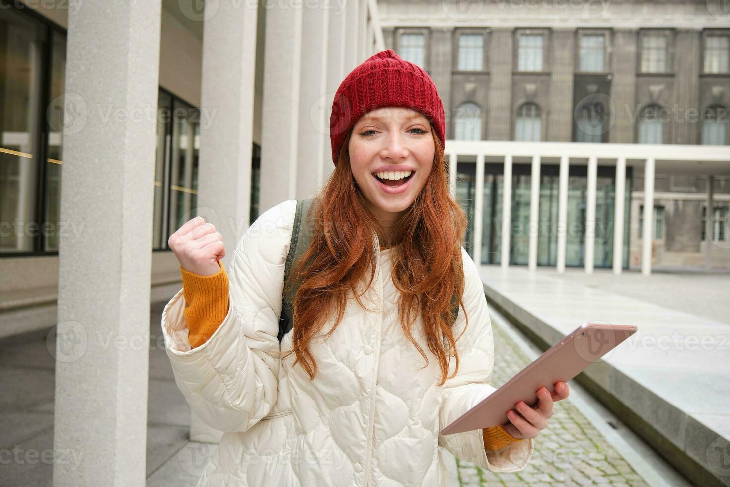 à moda gengibre garota, turista anda em com digital tábua por aí cidade, mulher conecta para internet em dela engenhoca, olhando acima Informação, mensagens de texto mensagem foto