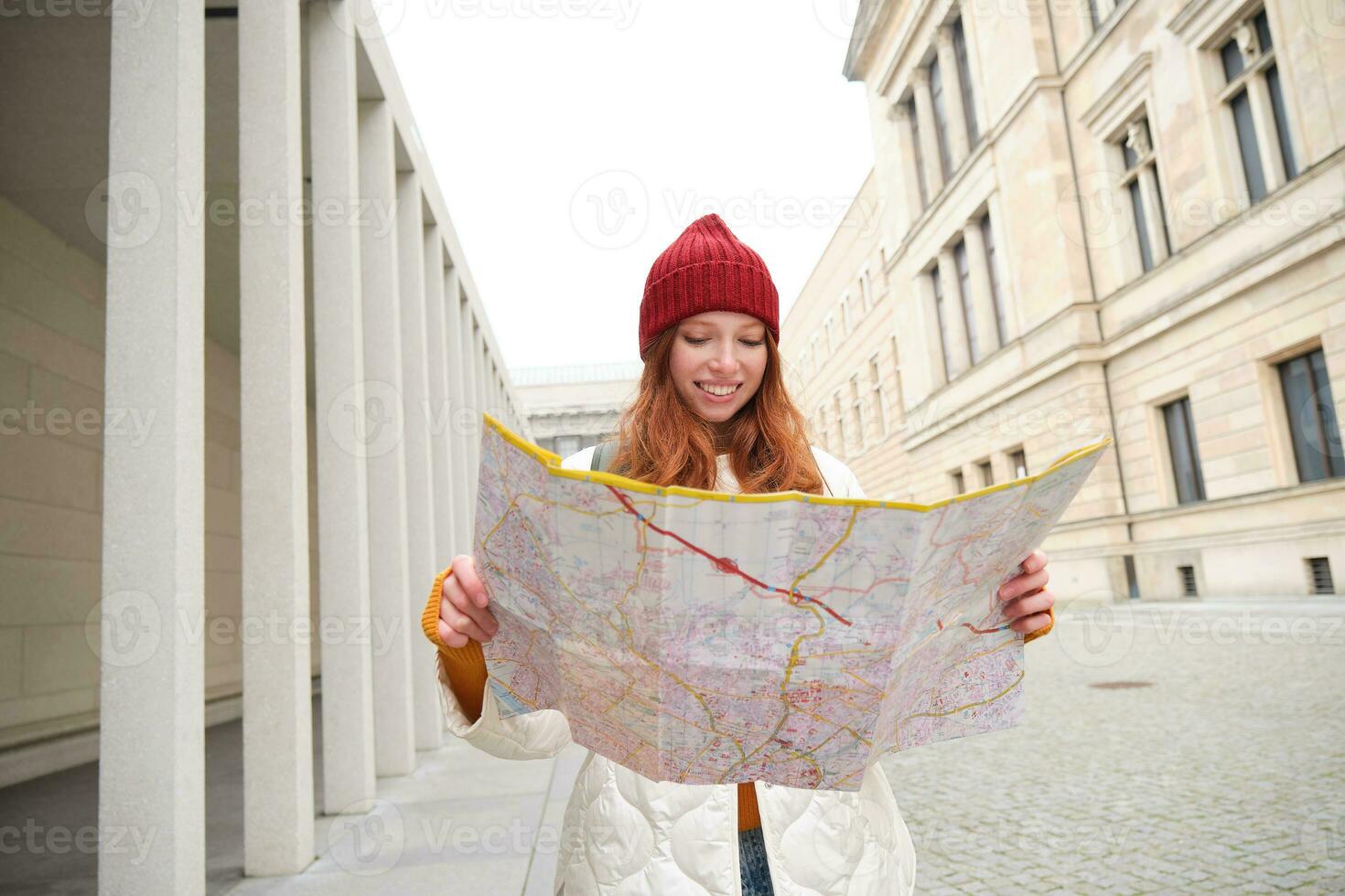 ruiva garota, turista explora cidade, parece às papel mapa para encontrar caminho para histórico marcos, mulher em dela viagem por aí Europa pesquisas para passeios turísticos foto