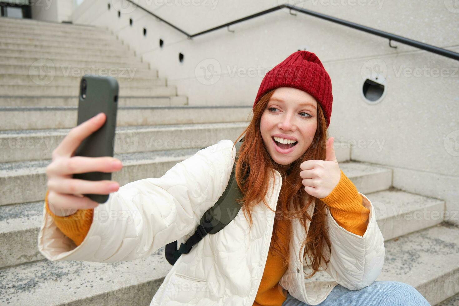 urbano menina leva selfie em rua escadaria, usa Smartphone aplicativo para levar foto do ela mesma, poses para social meios de comunicação inscrição