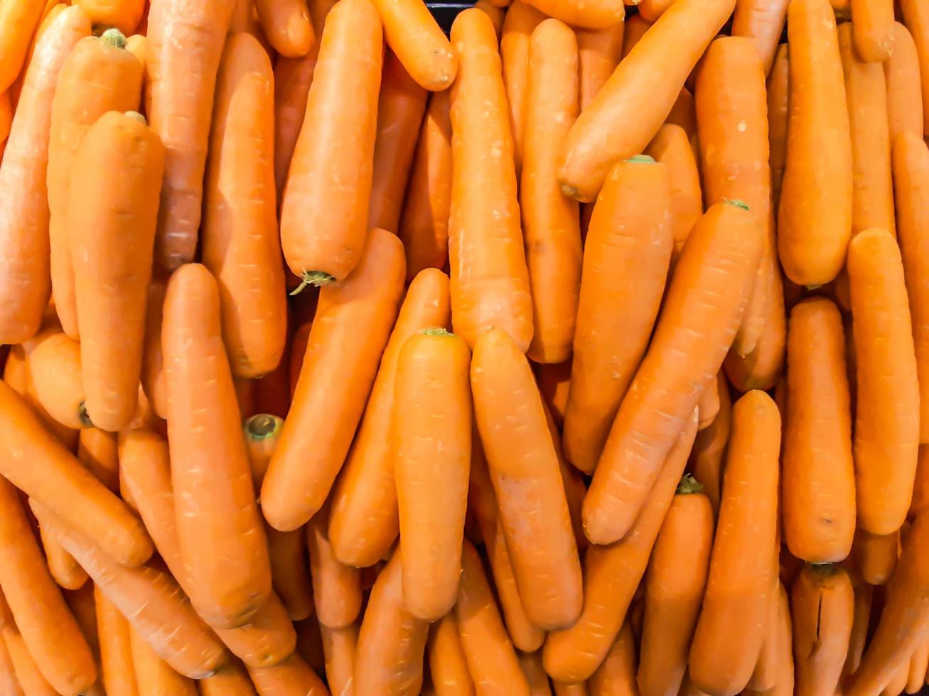 cenoura orgânica. fundo de textura de cenouras laranjas grandes frescas, as cenouras são boas para a saúde, cenouras maduras saudáveis para preparar a refeição foto