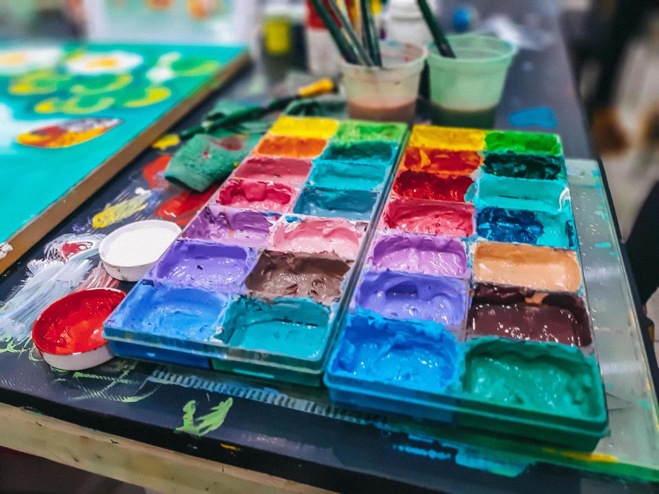 aquarela em uma paleta, a paleta de tintas de água na mesa, muitas cores na paleta de tintas de água foto