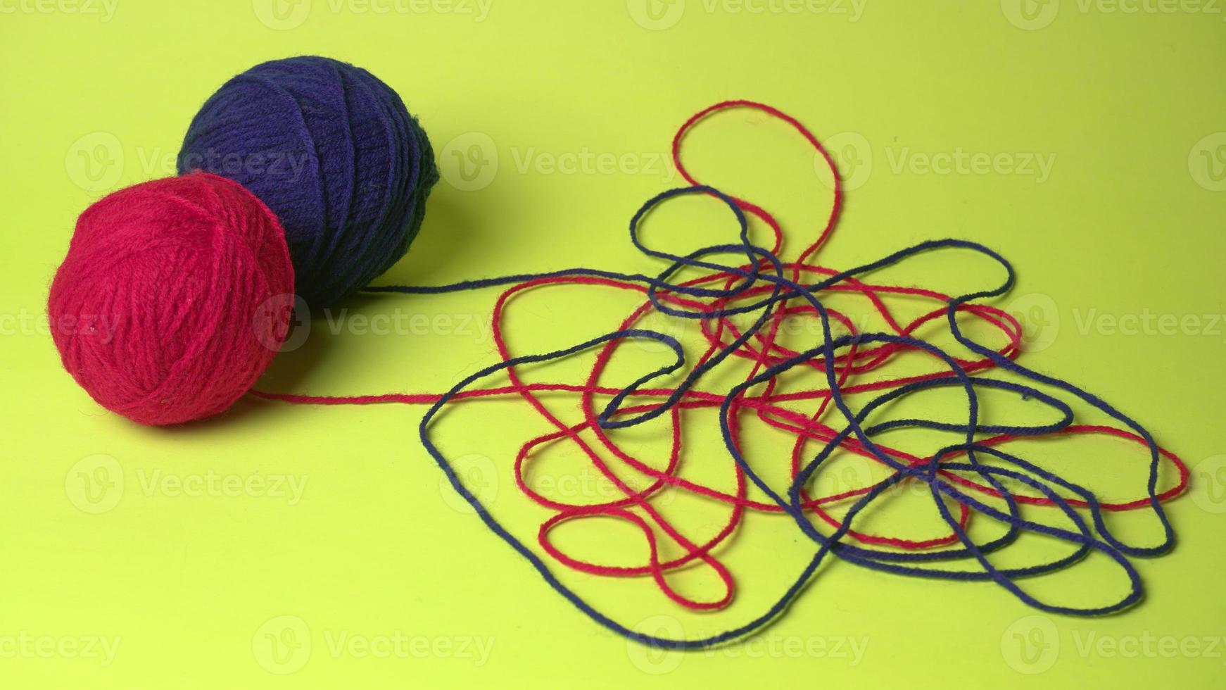 fios de cores, agulhas de tricô e roupas na mesa de madeira foto
