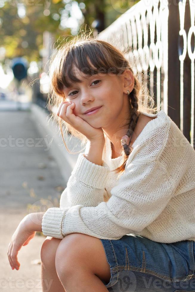 linda garota em um suéter branco e calça foto