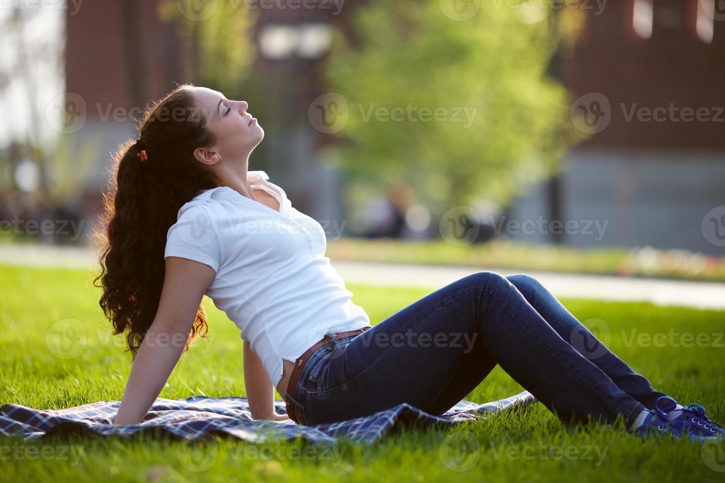 mulher feliz está sentada na grama foto