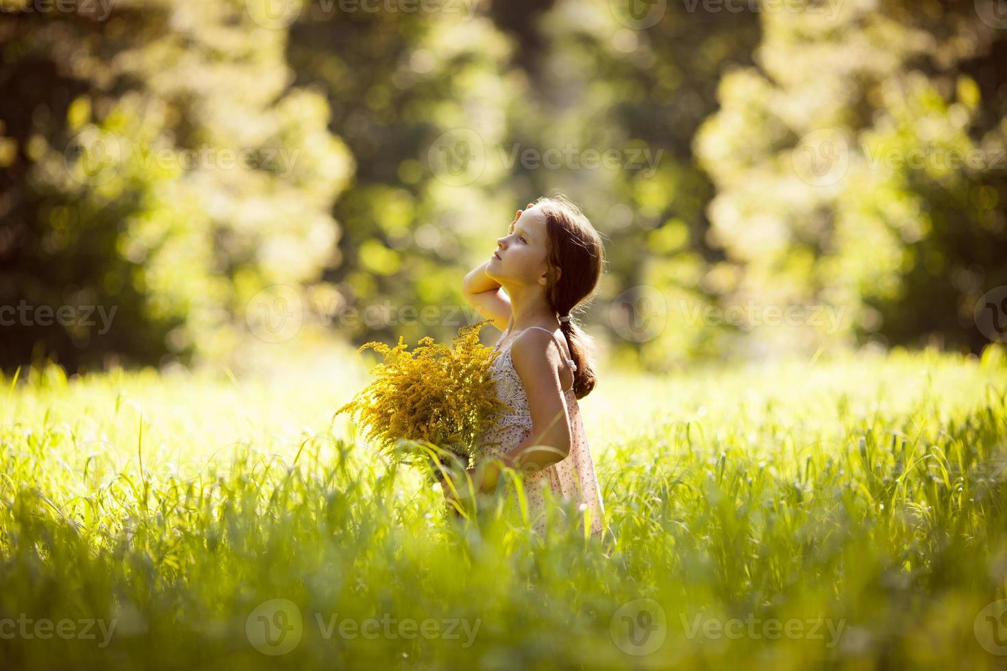 menina em pé com um buquê de flores amarelas foto
