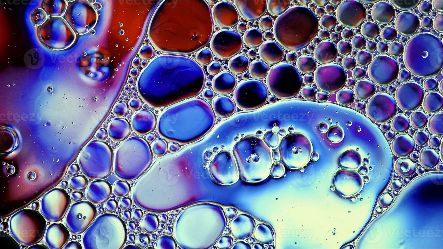 óleo de comida colorida abstrata gotas de bolhas e esferas fluindo na superfície da água foto