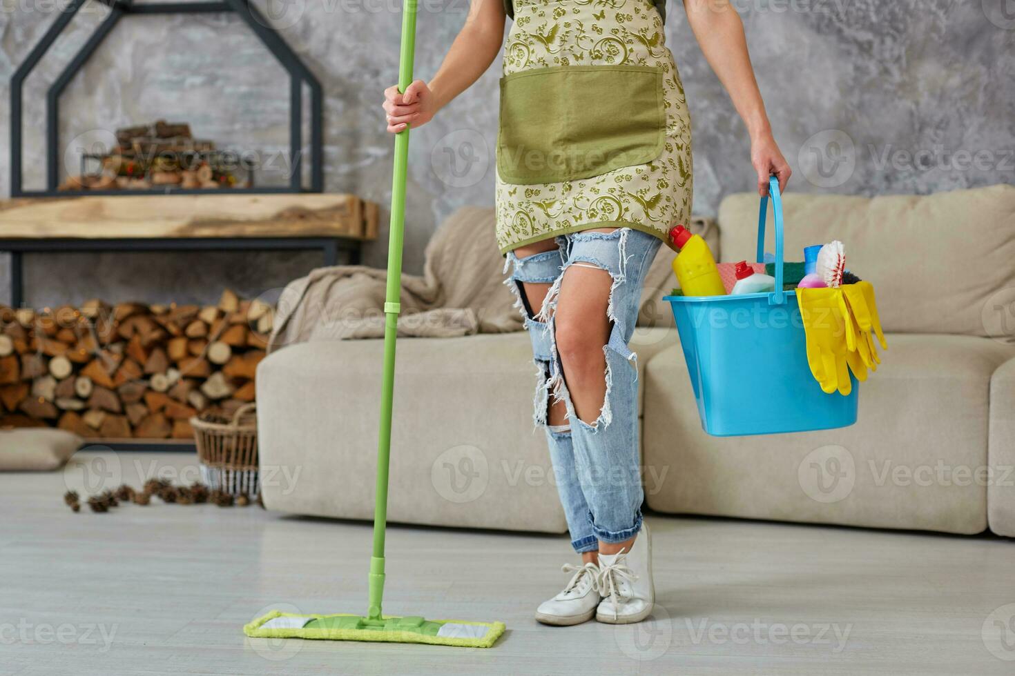 limpeza serviço. balde com esponjas, produtos químicos garrafas e esfregar grudar. cortada imagem do uma mulher com uma esfregão às a vivo quarto foto