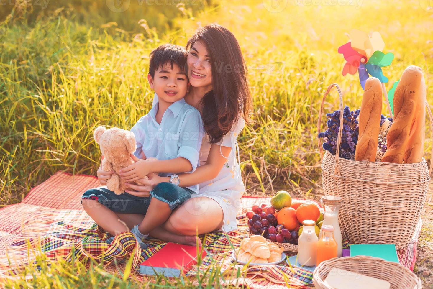 linda mãe asiática e filho fazendo piquenique e na festa de verão de Páscoa em Prado perto de lago e montanha. feriado e férias. estilo de vida de pessoas e conceito de vida familiar feliz. pessoa tailandesa foto