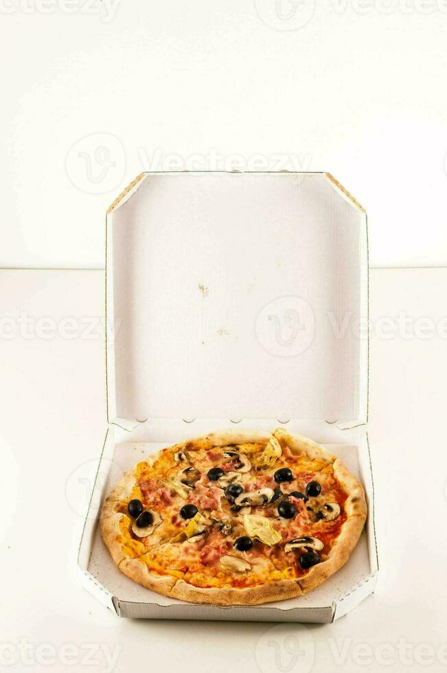 uma pizza dentro uma branco caixa em uma branco superfície foto
