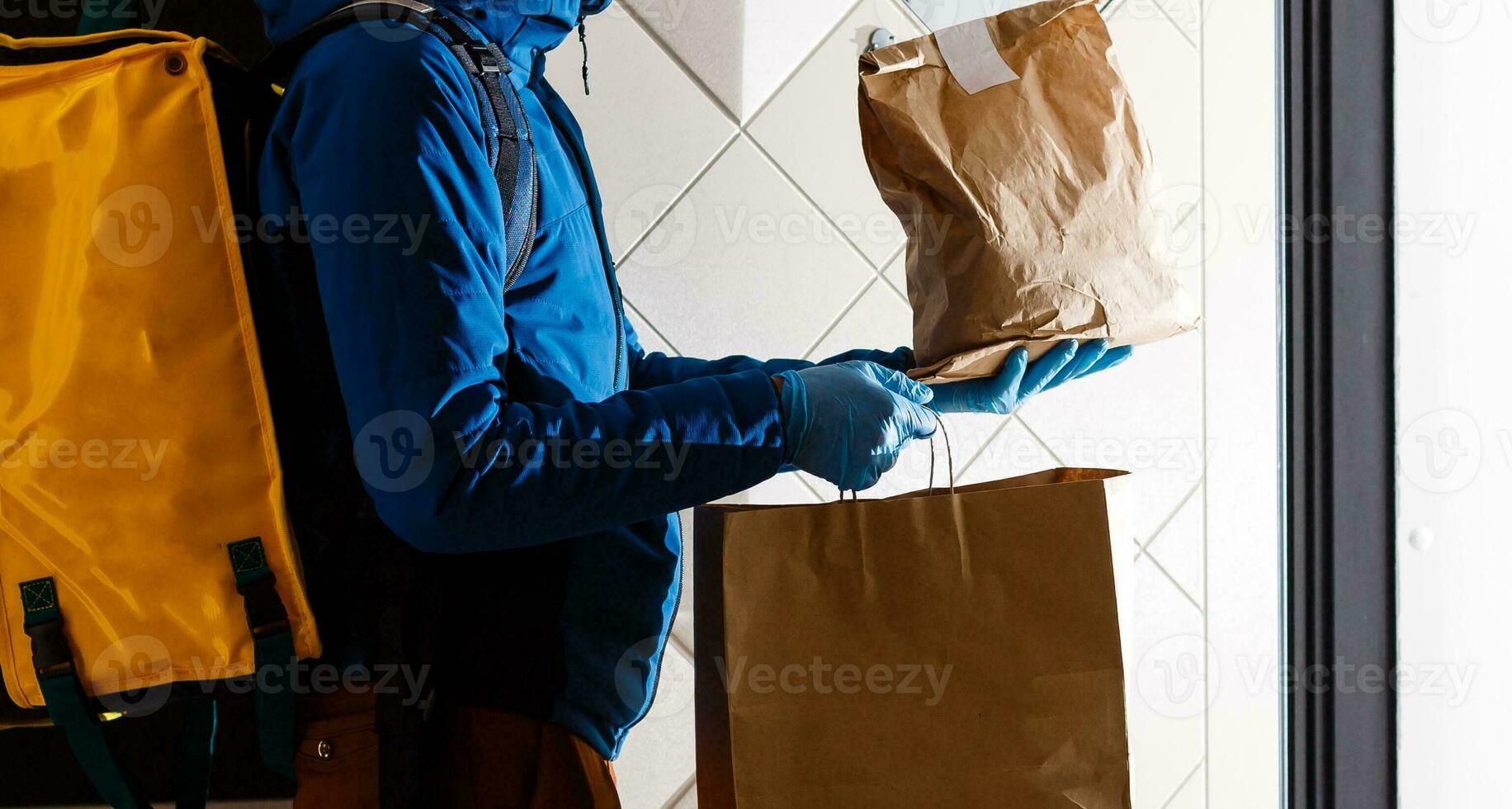 Entrega homem mandar Comida saco às porta botão para sem contato ou contato livre a partir de Entrega cavaleiro dentro frente casa para social distanciar para infecção risco. foto