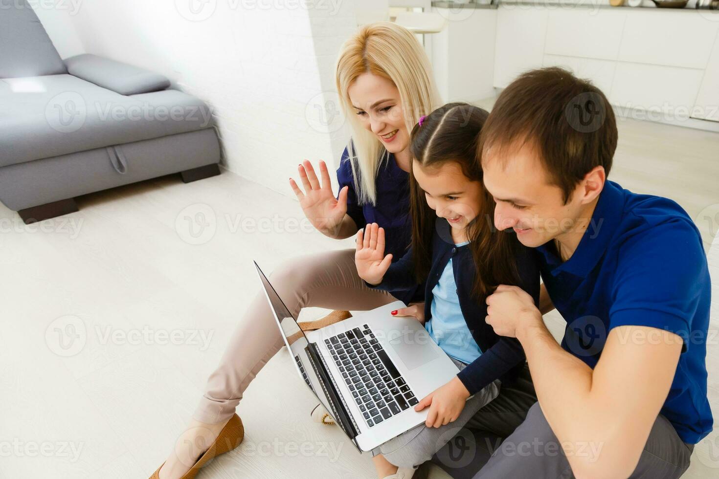 família topo Visão sentado em chão usando computador portátil computador dentro dela quarto às casa foto