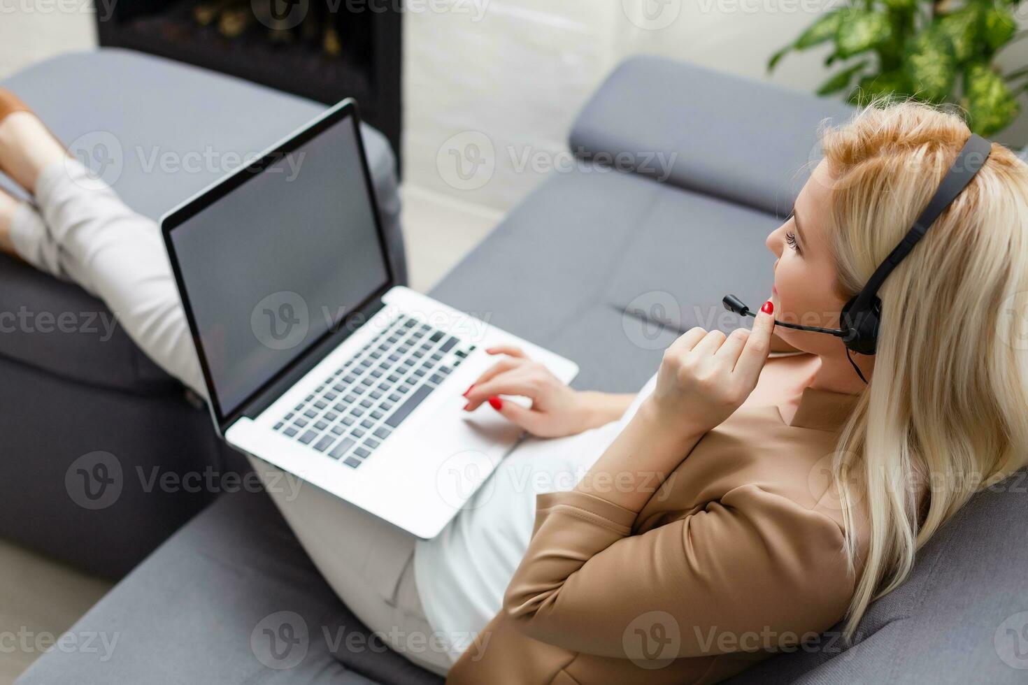 focado atento mulher dentro fones de ouvido senta com computador portátil, parece às tela, faz notas, aprende estrangeiro língua dentro Internet, conectados estude curso, auto-educação em rede, consulta cliente de vídeo foto