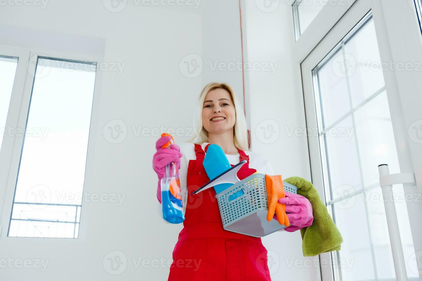 lindo jovem mulher faz limpeza a casa. menina esfrega pó. foto