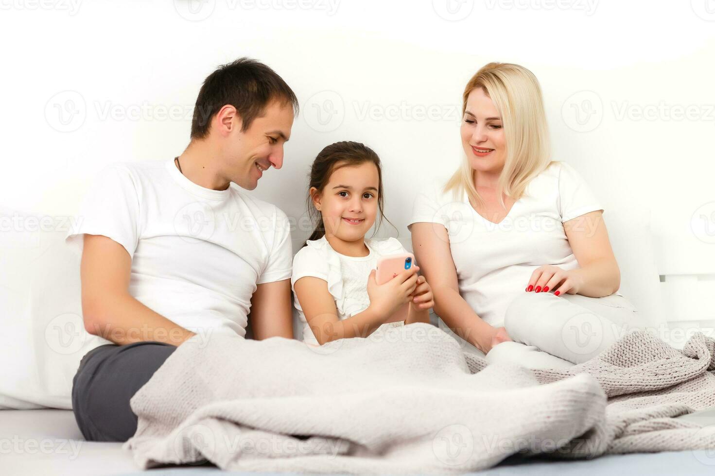 animado família comprando conectados deitado baixa em cama às casa foto
