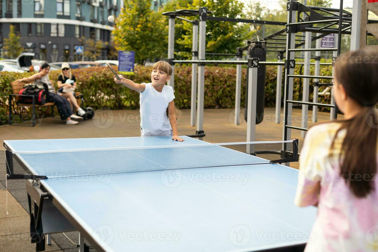 pequeno menina jogando mesa tênis dentro a tênis salão, tênis raquete batendo a bola, a arremesso do a bola. foto