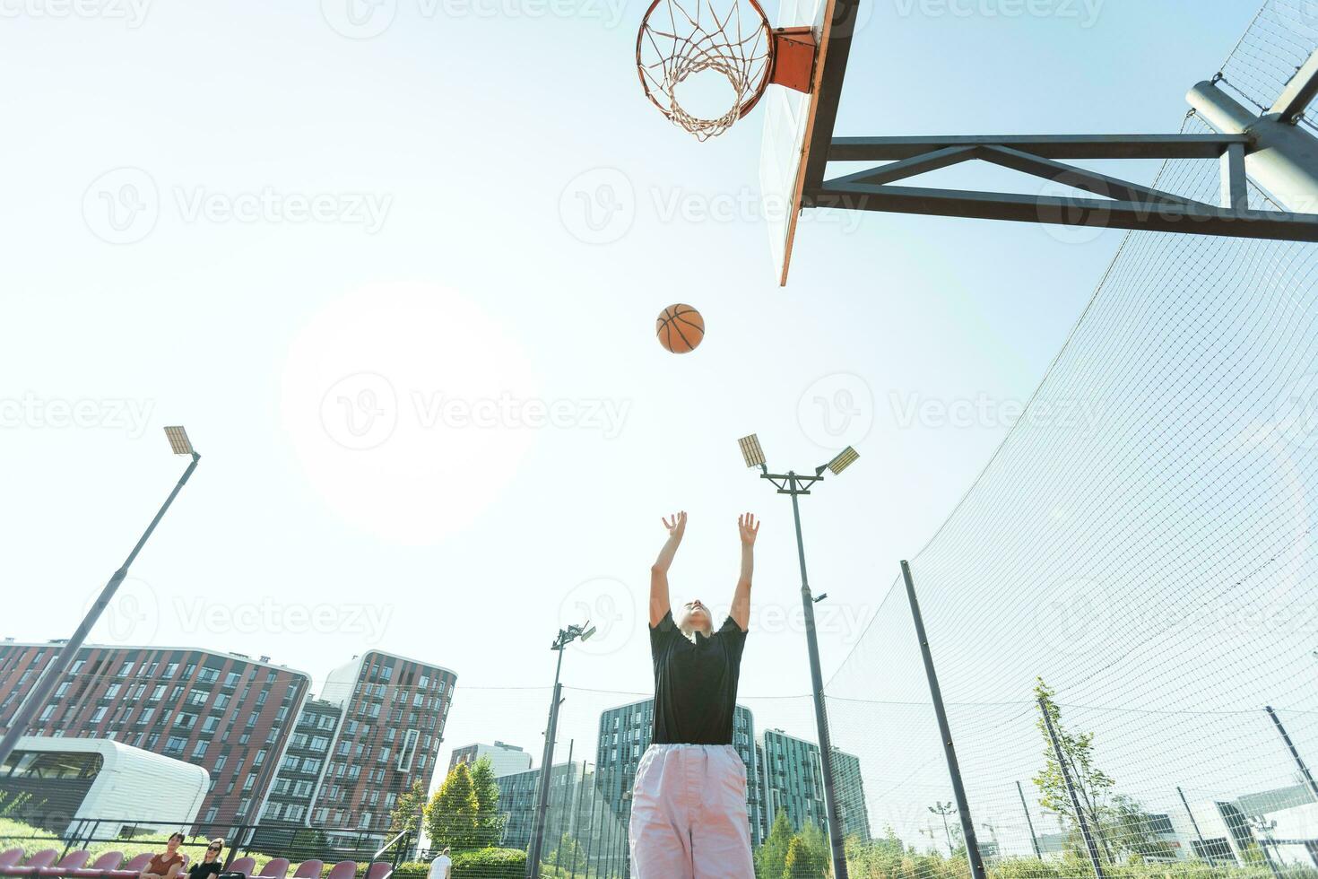 conceito do Esportes, hobbies e saudável estilo de vida. jovem Atlético menina é Treinamento para jogar basquetebol em moderno ao ar livre basquetebol tribunal. feliz mulher foto