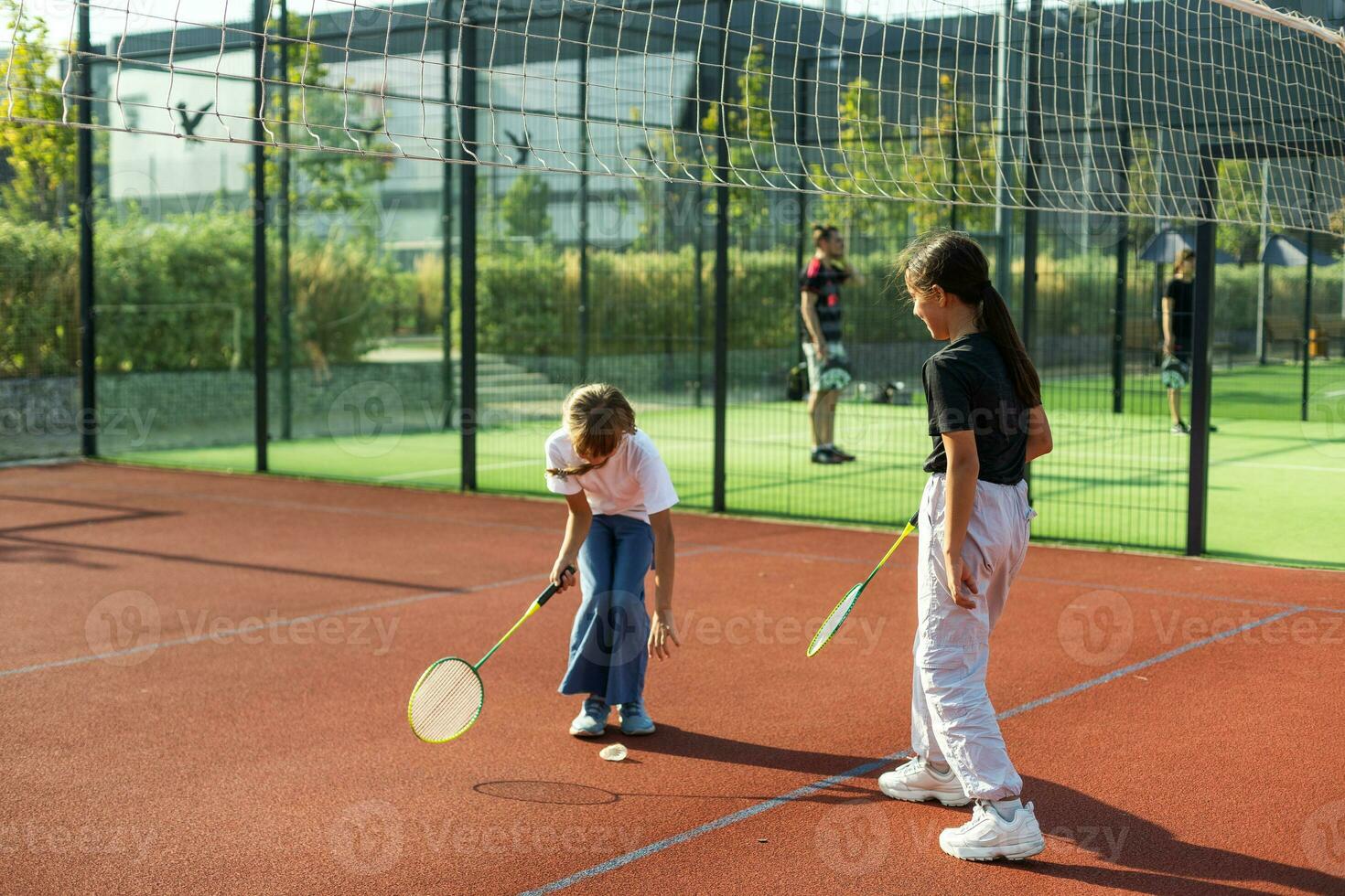 dois meninas com badminton raquetes em a futebol campo. foto