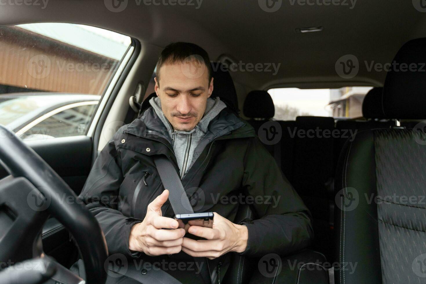 sucesso em movimento. jovem bonito de terno completo sorrindo enquanto dirigia um carro foto