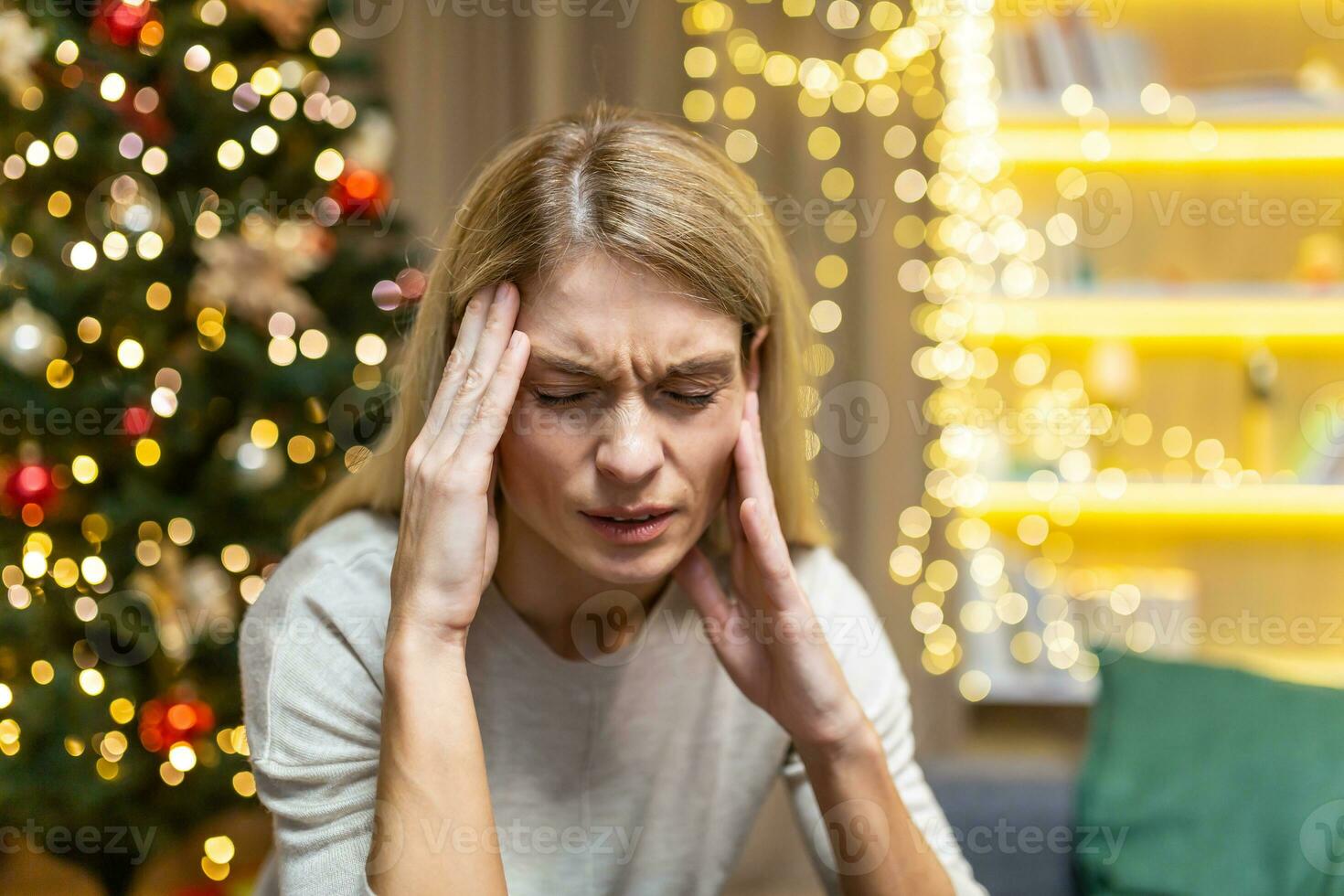 triste mulher sozinho às casa para Natal e Novo ano, sentado depressivo perto Natal árvore em sofá dentro vivo sala, esperando para celebração. foto