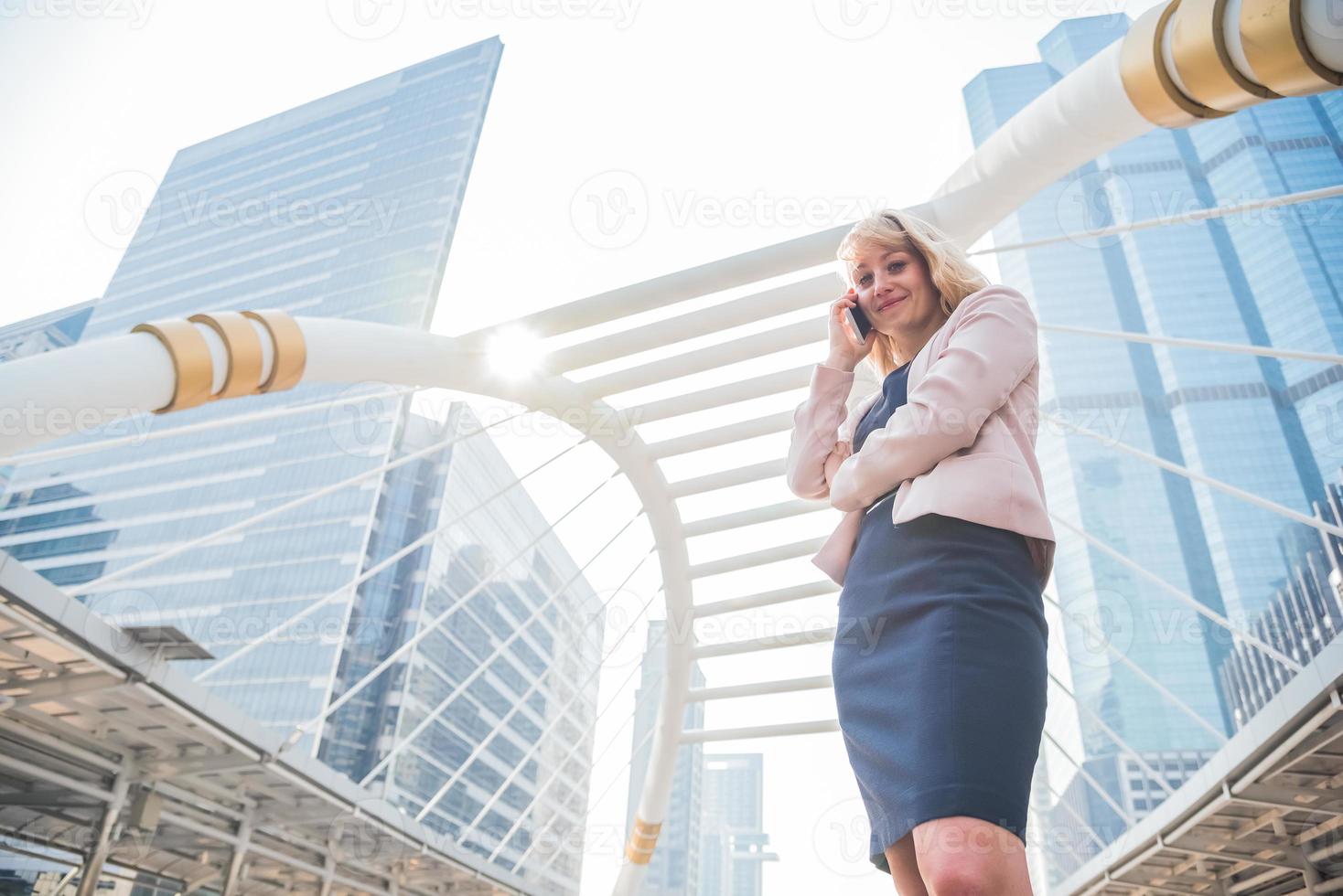 mulher de negócios de beleza usando telefone celular para se comunicar com clientes na cidade. conceito de negócios e tecnologia. tema metrópole foto