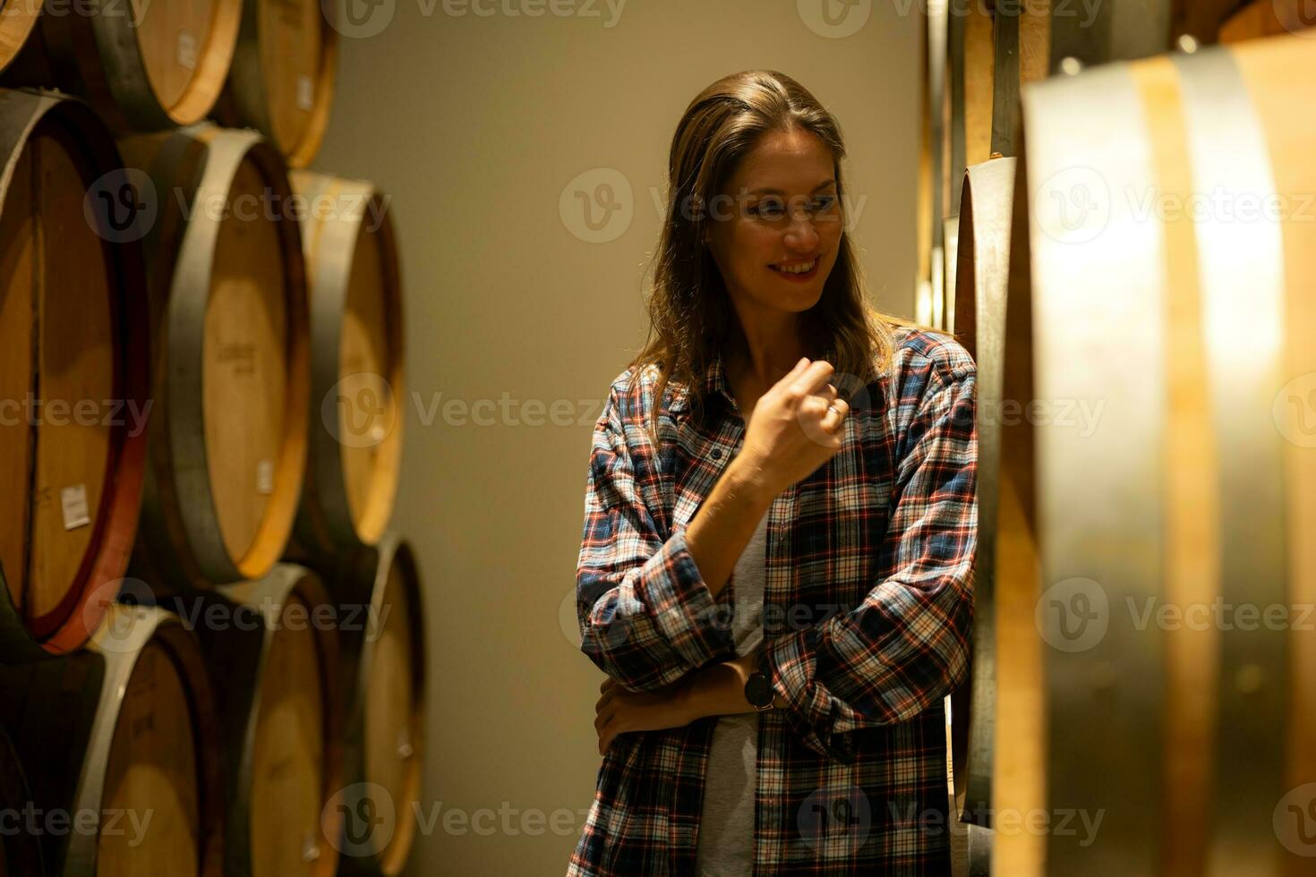 retrato do uma jovem mulher cercado de vinho barris dentro dela adega foto