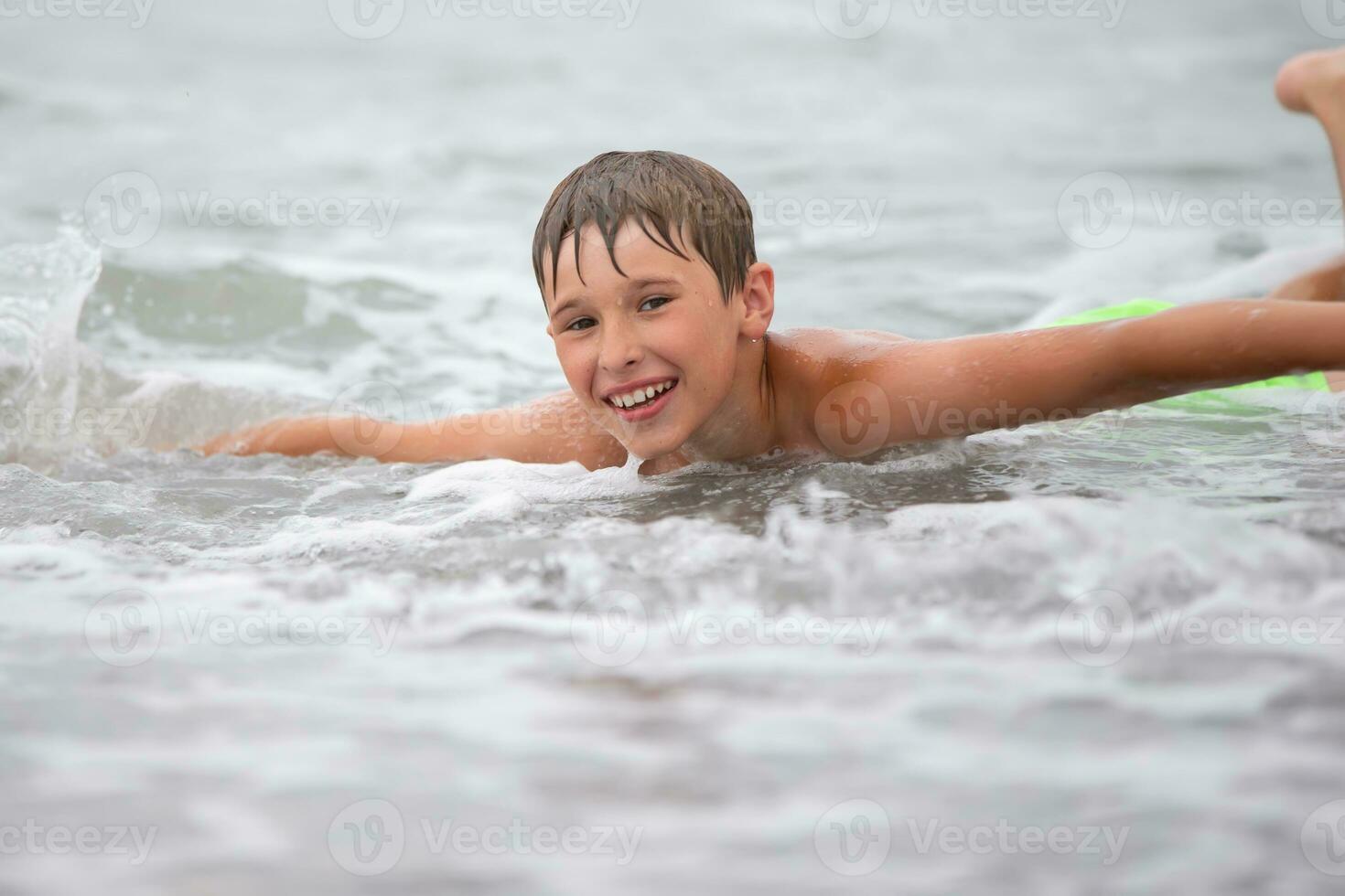 a face do uma feliz Garoto quem nada dentro a mar. foto