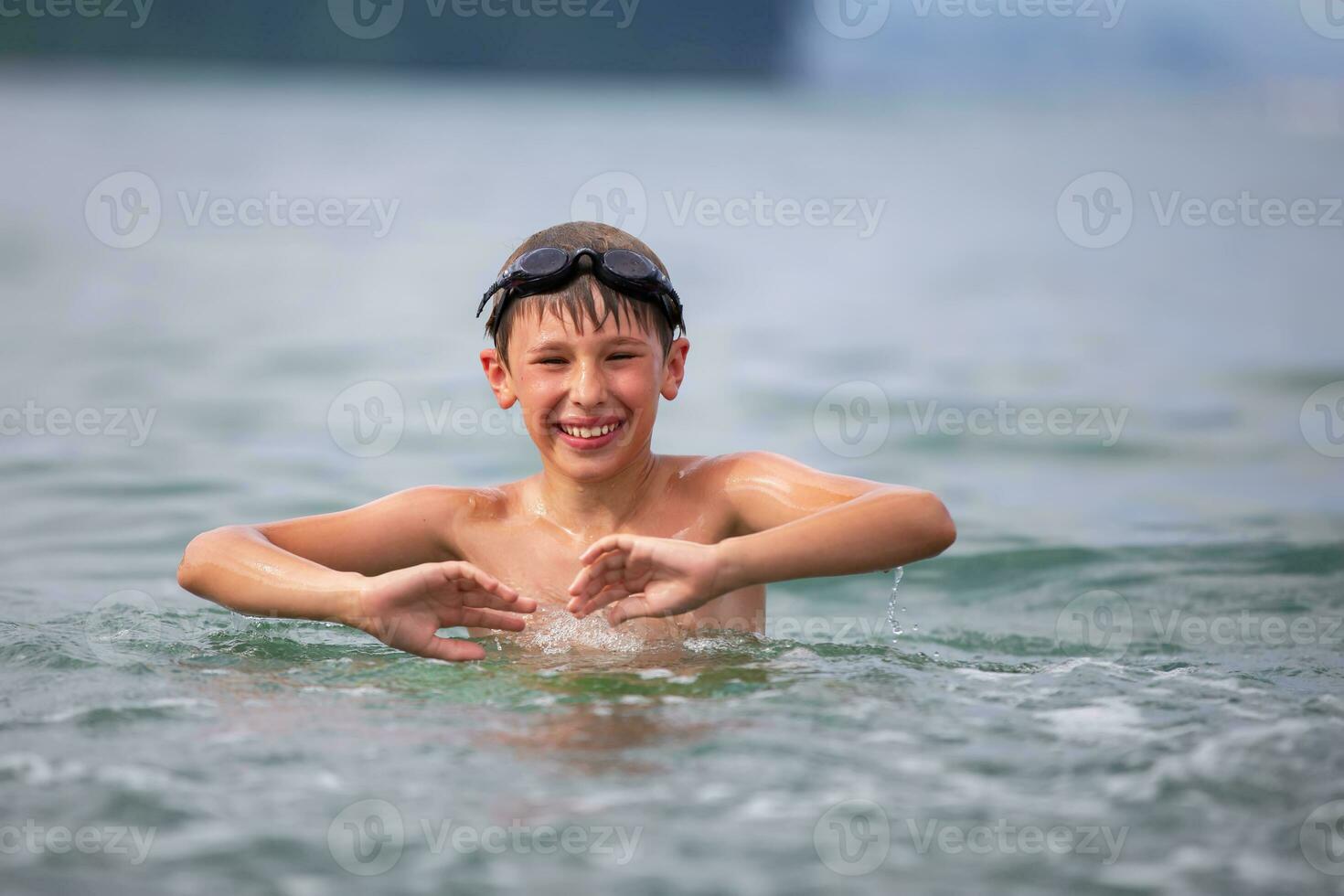 uma Garoto dentro natação óculos nada dentro a mar. foto