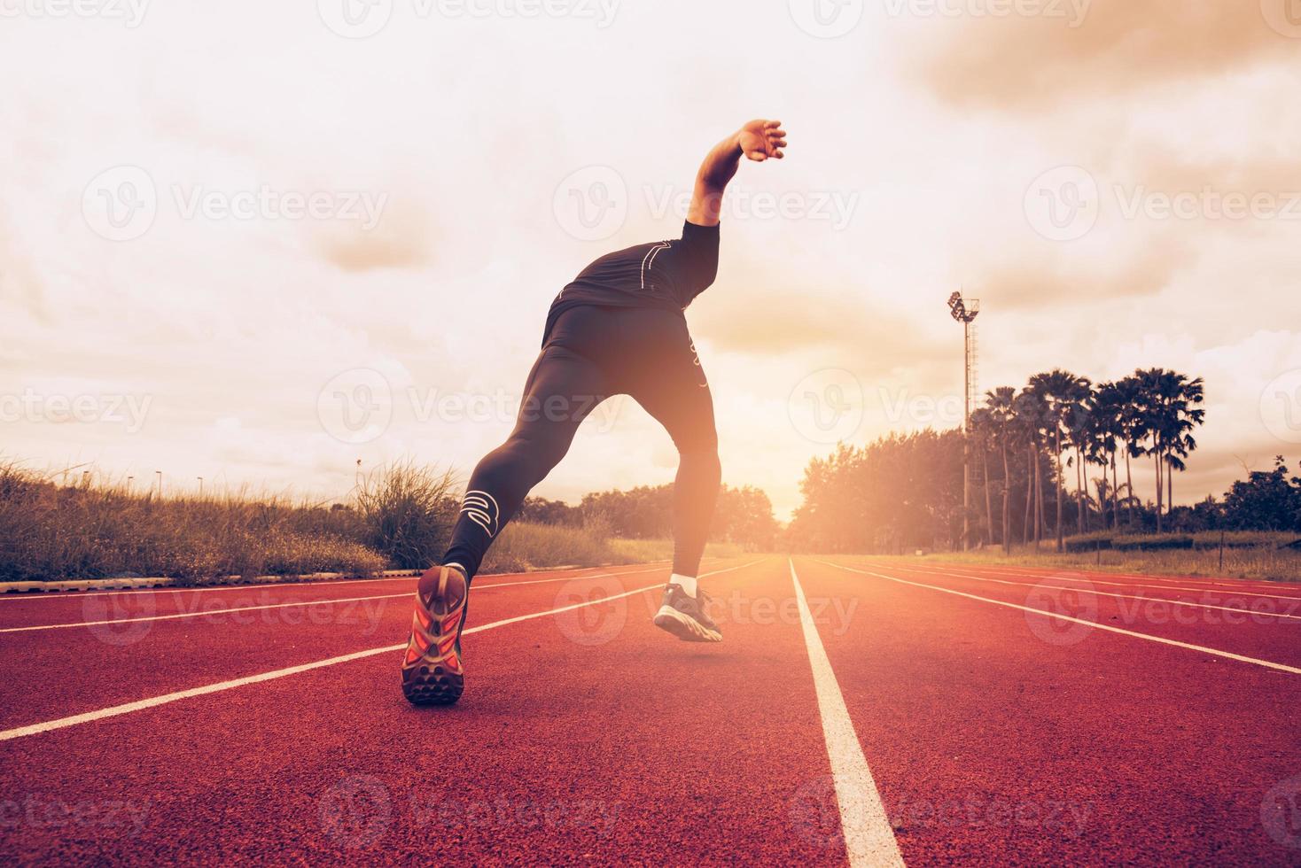pôr do sol e jovem correndo na pista. sucesso e objetivo do conceito de negócio. esporte atlético e tema de exercício foto
