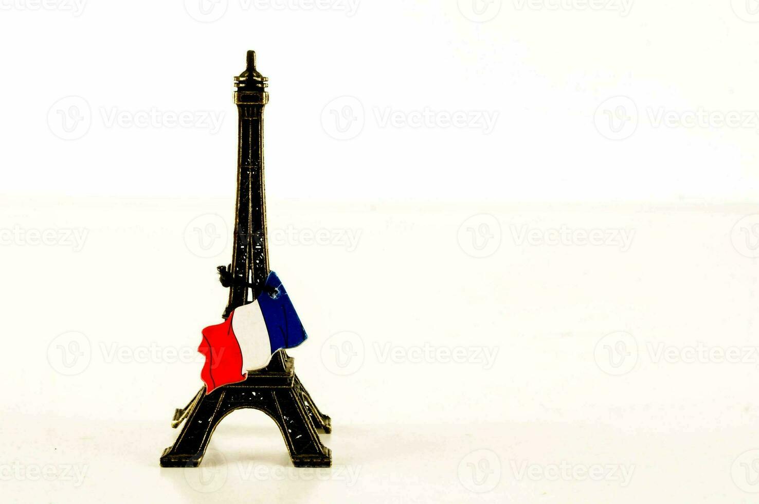 uma miniatura eiffel torre com uma francês bandeira em topo foto