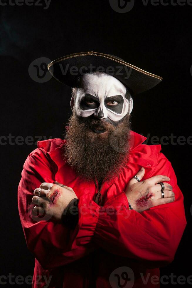 ator com sangue em dele mãos vestindo uma assustador pirata roupa. foto