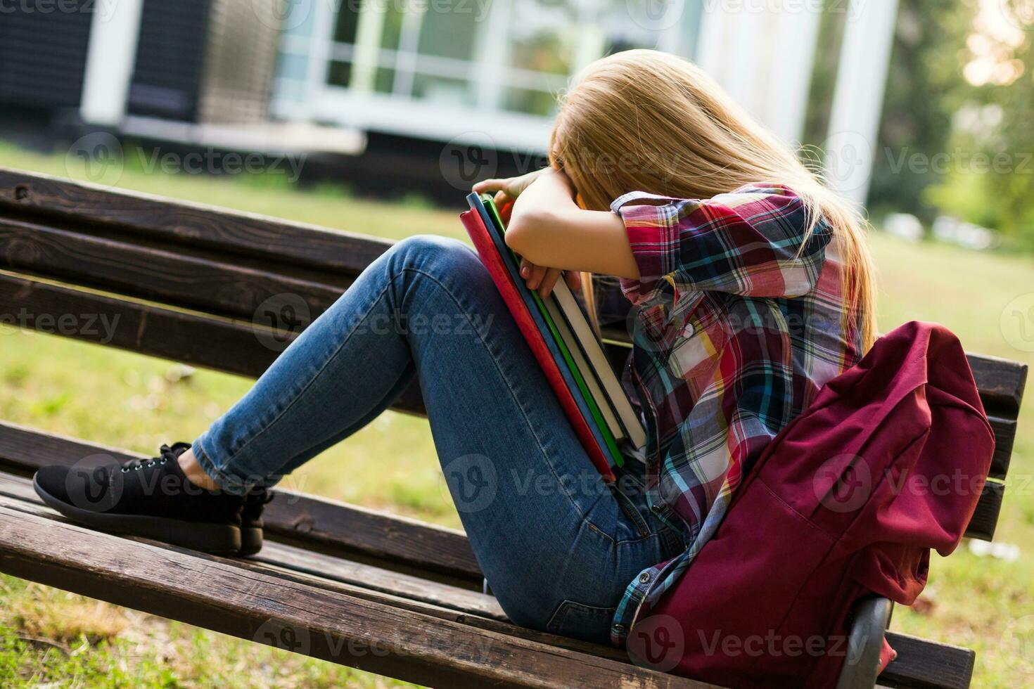 Exausta e cansado fêmea aluna estudando ar livre. foto