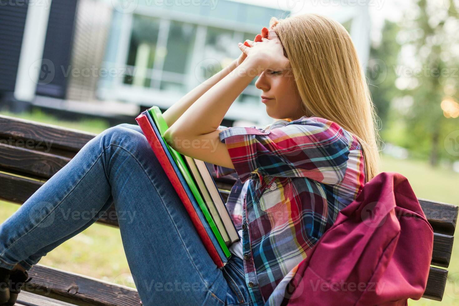 Exausta e preocupado fêmea aluna estudando ar livre. foto